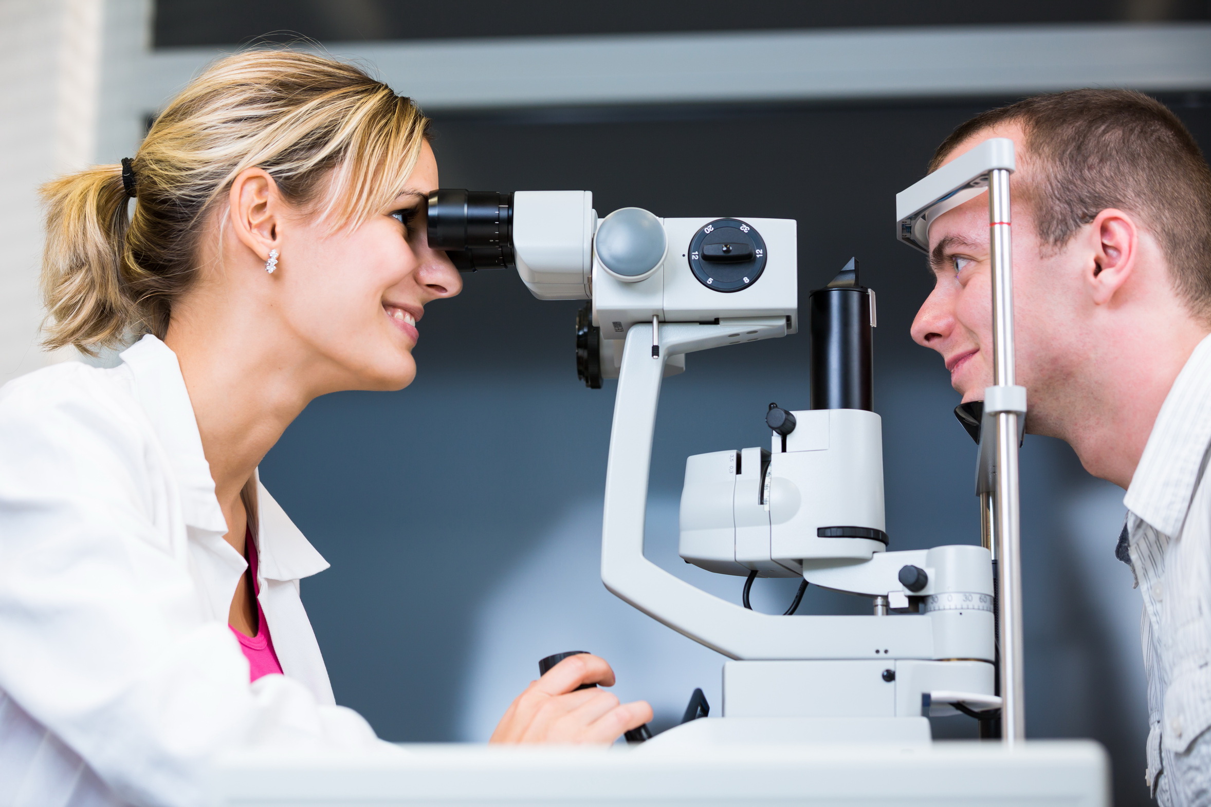 optometry concept - handsome young man having her eyes examined