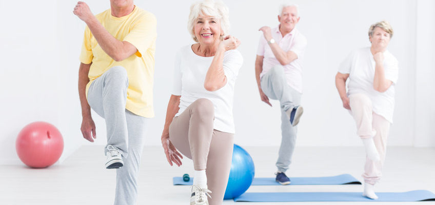 Group of active seniors exercising at the gym and smiling